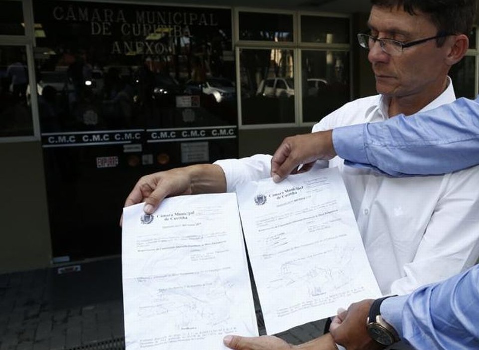 O vereador Pedro Paulo mostra os documentos rasgados pelo vereador Valdemir Soares | Hugo Harada / Agência de Notícias Gazeta do Povo