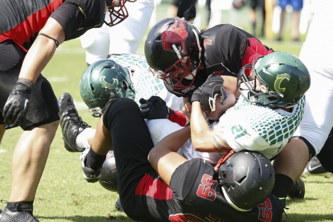 Running back Mullet, do Crodiles, disputa a bola com jogadores do Espectros |