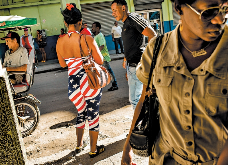 Uma mulher usa roupa de inspiração norte-americana em uma rua de Havana | Tomas Munita para The New York Times