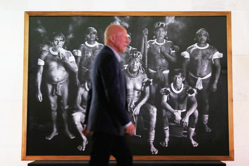 Sebastião Salgado (fora de foco) diante de uma das imagens da exposição Genesis, no MON | Ueslei Marcelino/Reuters
