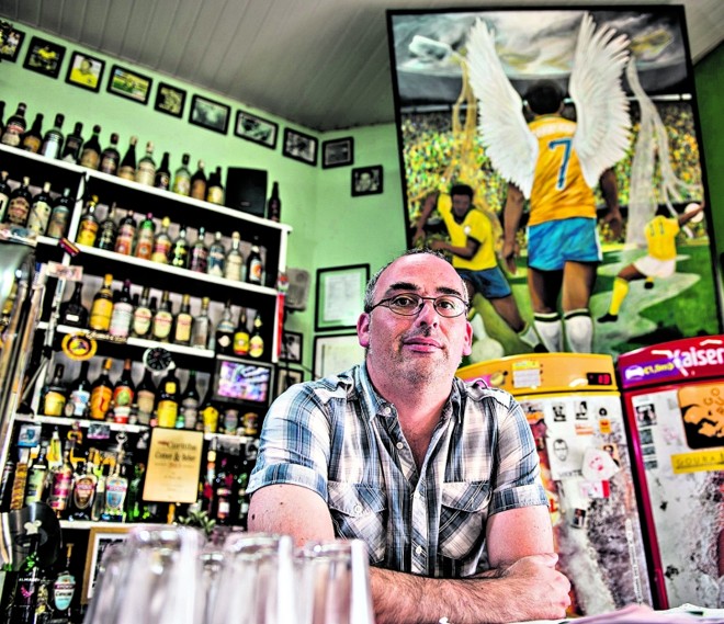 Rodrigo Lobão em frente à sua obra, no bar O Torto. Artista começou a pintar aos 13 anos, quando roubava tintas da mãe | Henry Milléo/ Gazeta do Povo