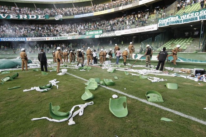 A destruição no gramado do Couto Pereira, enquanto a polícia tenta conter a invasão. |