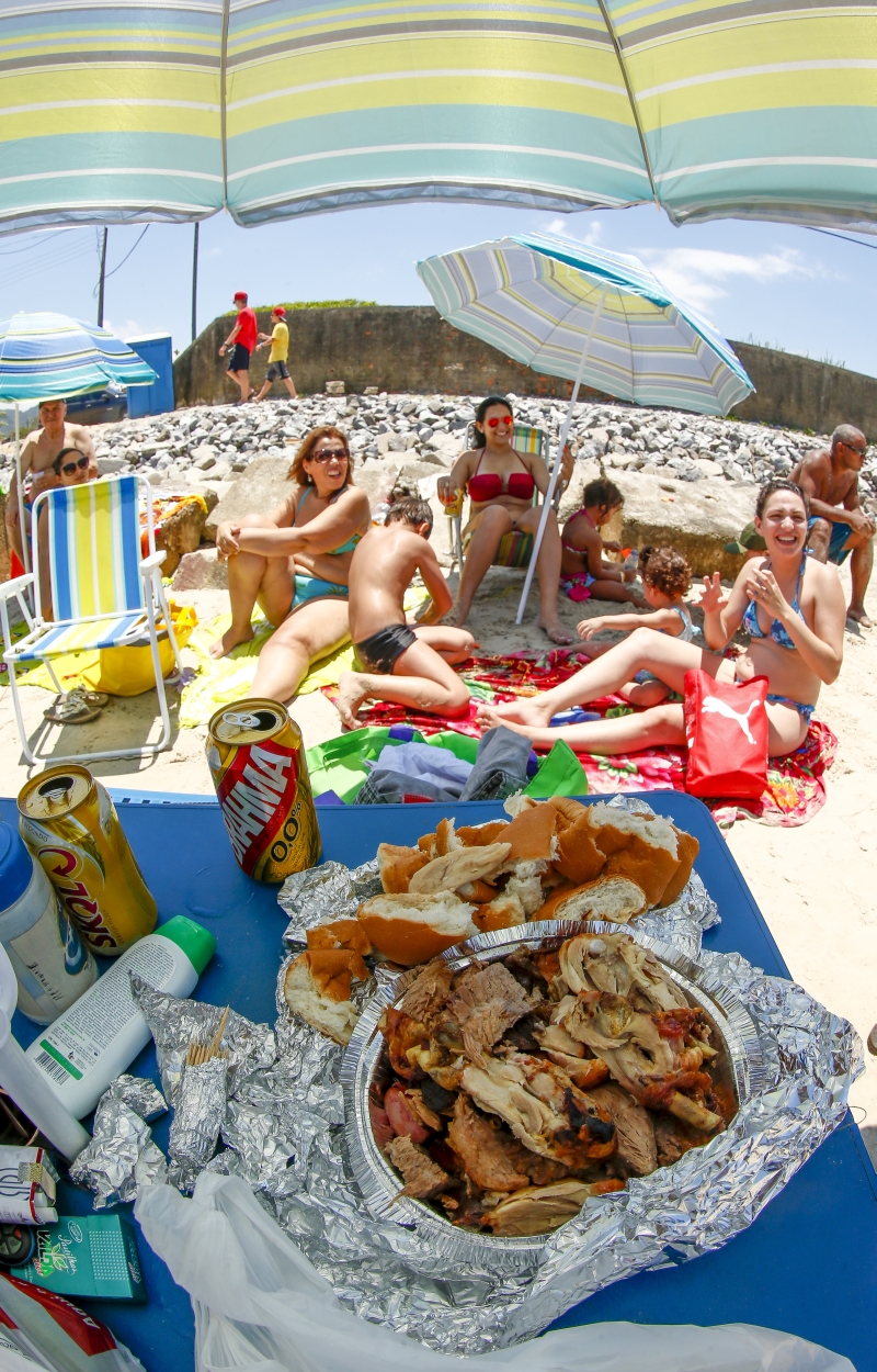 Para tentar gastar menos no litoral, famílias como a Rocha levam comida para a areia | Hugo Harada/Gazeta do Povo