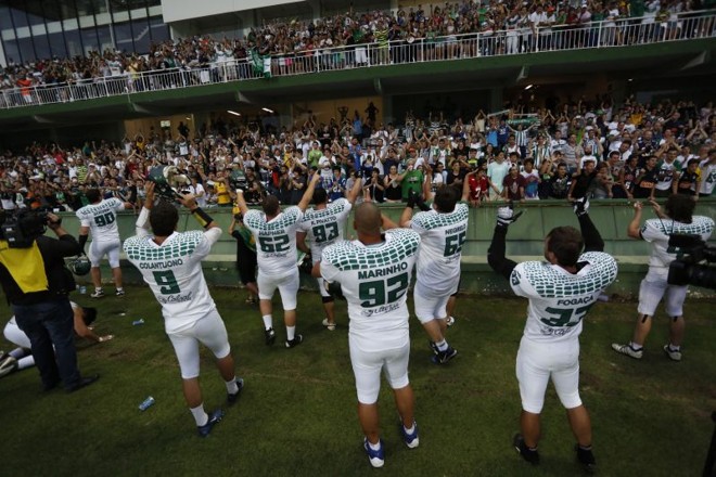 Jogadores do Crocodiles comemoram com a torcida a conquista do bi no futebol americano |