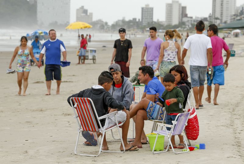 O vento frio e a garoa não espantaram alguns corajosos veranistas que se arriscaram ao entrar no mar ou ficar na orla da praia | Hugo Harada / Gazeta do Povo
