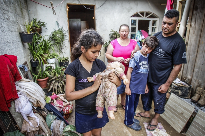 As poucas bonecas que Elisama tinha ficaram sujas de barro. Ela e o irmão Gabriel não ganharam presentes no Natal | Daniel Castellano/Gazeta do Povo