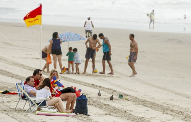 O vento frio e a garoa não espantaram alguns corajosos veranistas que se arriscaram ao entrar no mar ou ficar na orla da praia |