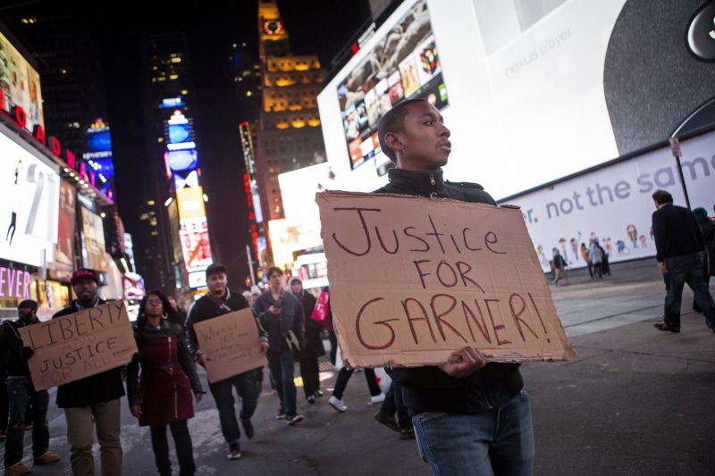 Jovem segura cartaz durante protesto que terminou em tumulto em Nova York | Eric Thayer/Reuters