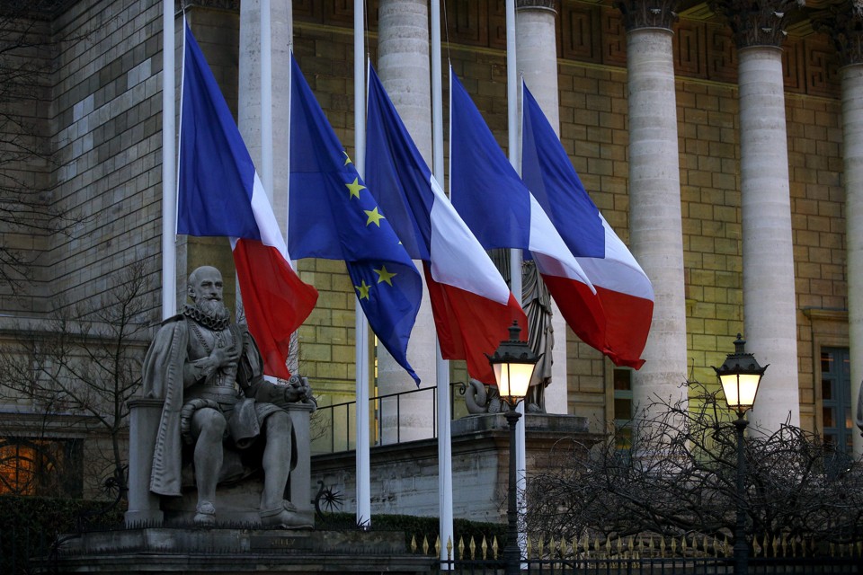 Bandeiras da França a meio-pau no Parlamento, em Paris, nesta quarta-feira (7) | Yoan Valat/EFE