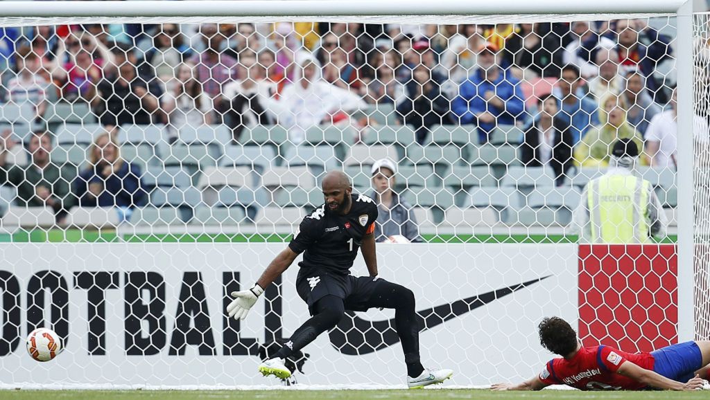 Young-Cheol, caído, vê a bola enganar o goleiro Al-Habsi, no único gol da partida disputada em Canberra. | Tim Wimborne/ Reuters