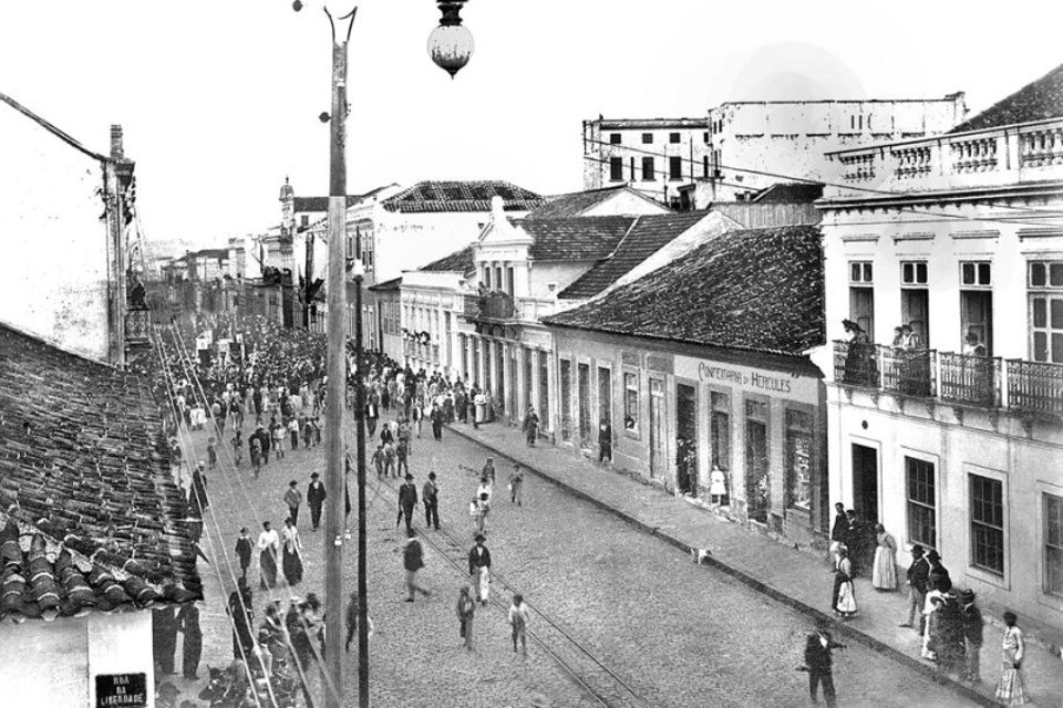 A passeata avança pela Rua Quinze, em direção a Rua Barão do Rio Branco, em protesto sobre a questão de limites entre o Paraná e Santa Catarina. Foto de 1904 | 