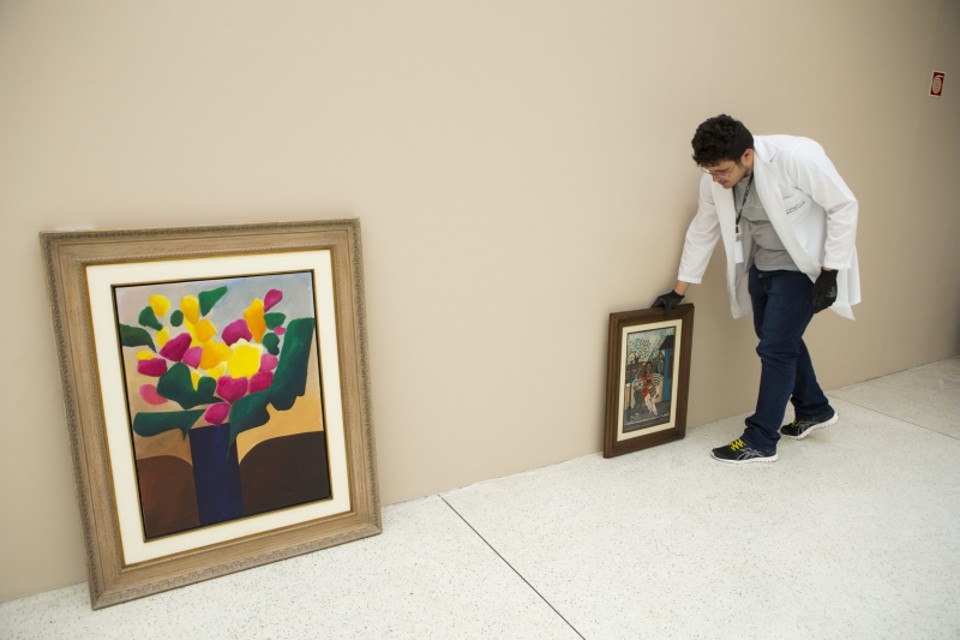 Funcionário do Museu Oscar Niemeyer arruma telas para a exposição que abre à visitação amanhã | Brunno Covello/Gazeta do Povo