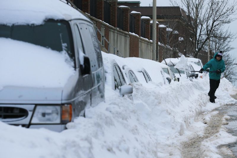 Morador de Somerville, em Massachusetts, retira neve acumulada na rua e sobre os carros | Brian Snyder/Reuters
