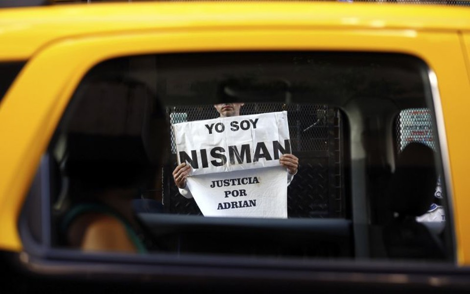 Homem segura cartaz em frente ao escritório de Alberto Nisman | Marcos Brindicci/Reuters