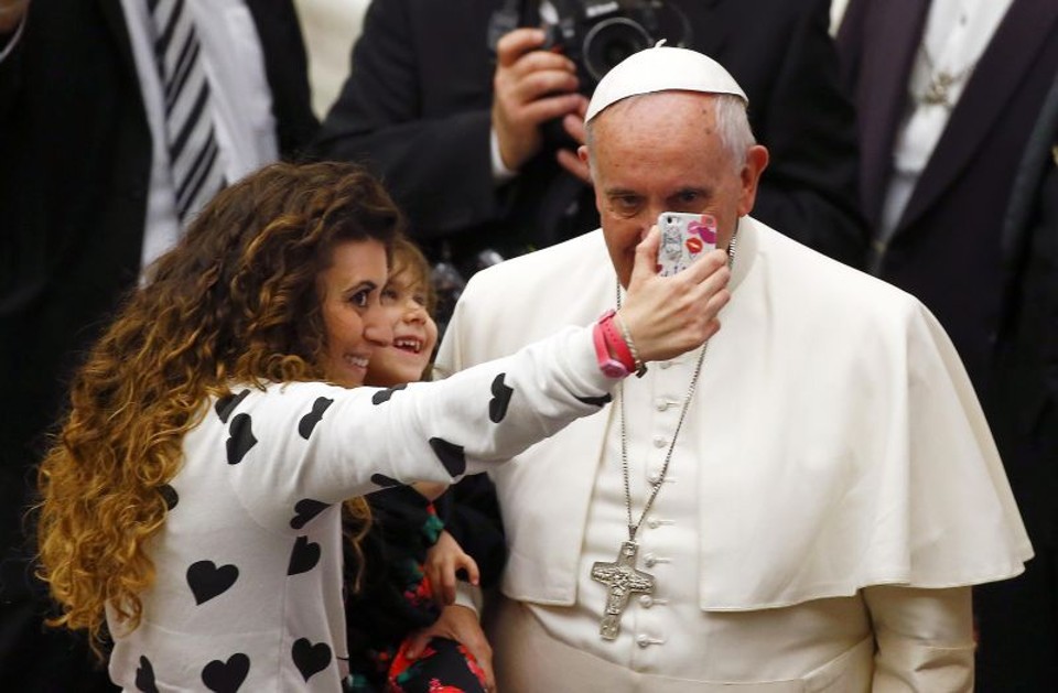 Mulher usa o celular para fazer foto ao lado do papa Francisco no Vaticano | Tony Gentile /Reuters