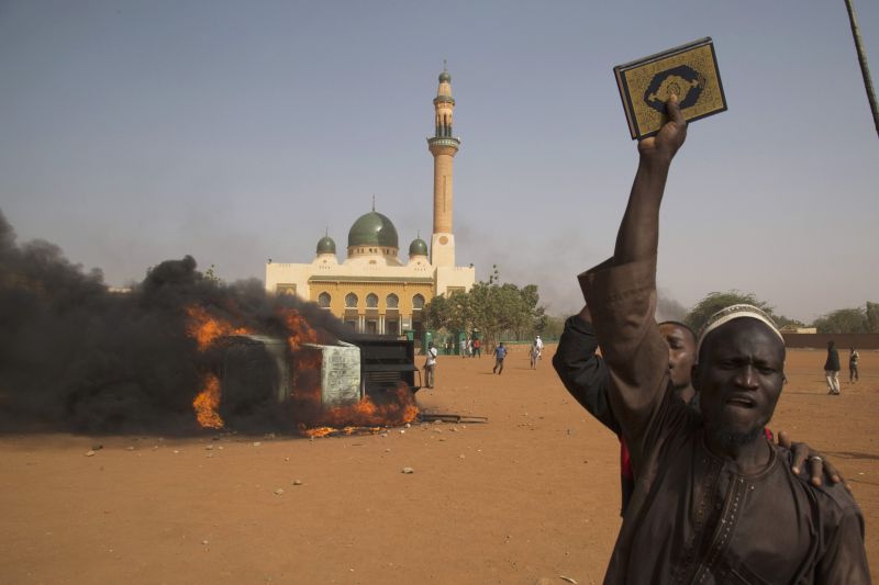 Um homem segura um exemplar do Alcorão durante protestos no Níger | REUTERS / Tagaza Djibo