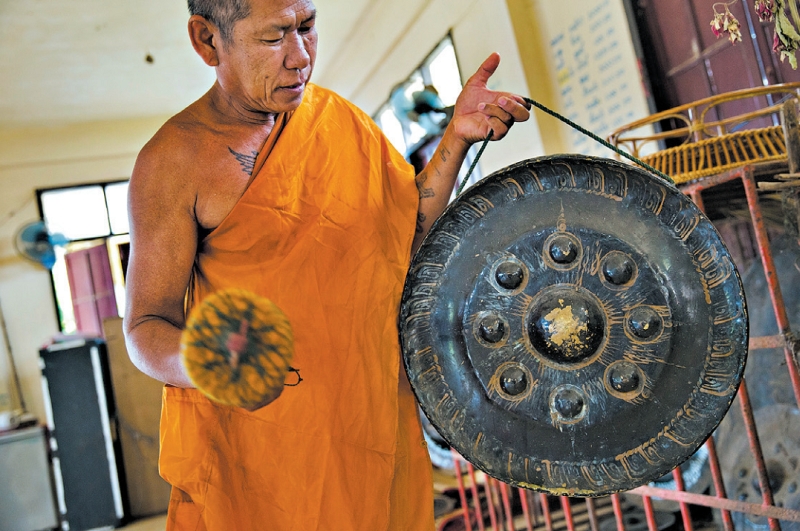 Lojas na estrada do gongo na Tailândia vendem peças pequenas como souvenir por cerca de US$25. Um monge budista em Ubon Ratchathani | Adam Ferguson para The New York Times