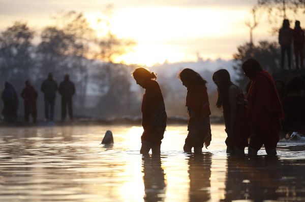 Devotos entram no rio Triveni para oferecer a oração antes de tomar um banho santo durante o festival Swasthani Bratakatha em Panauti | REUTERS/Navesh Chitrakar