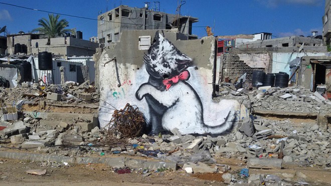 Arte de Banksy em muro parcialmente destruído de Gaza. | Divulgação/Reuters