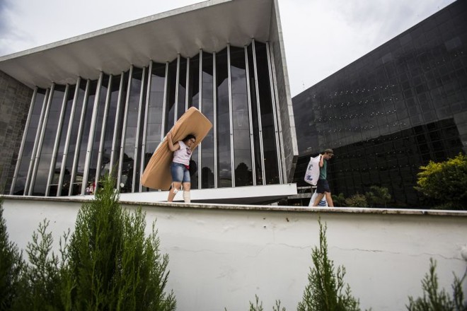 Servidora carrega colchão na rampa da Alep |