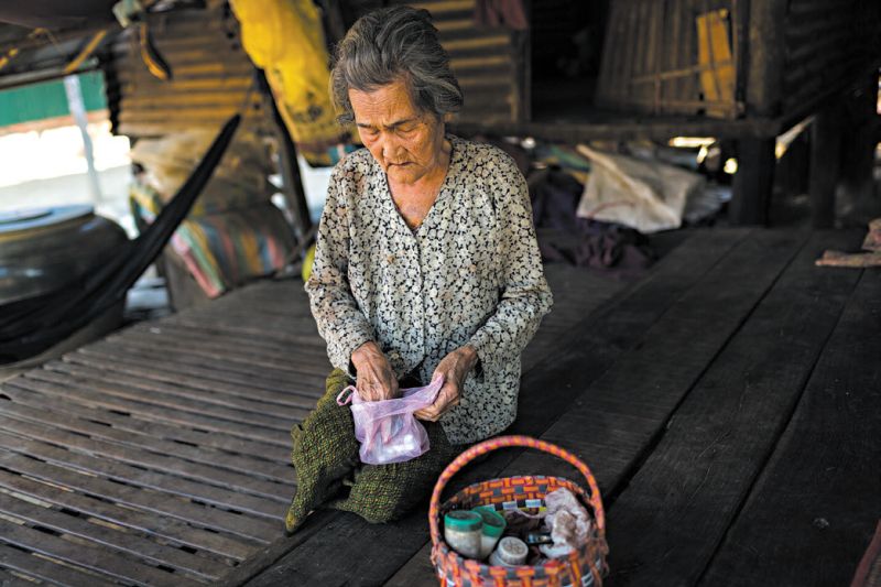 Chhay Yao, 76 anos, com sua medicação antirretroviral. Dezesseis pessoas de sua família foram infectadas com o vírus HIV | Nicolas Axelrod para The New York Times