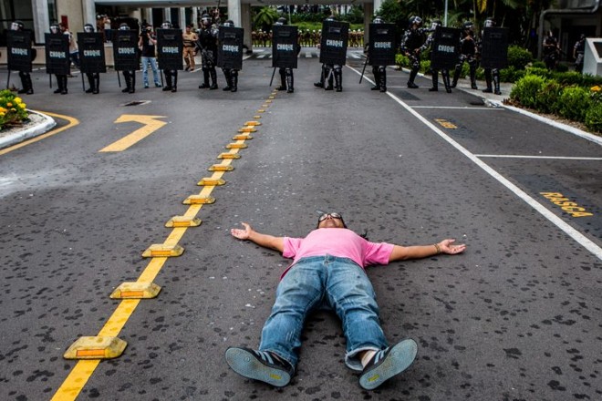 Servidor deita no chão para tentar impedir o avanço da tropa de choque |