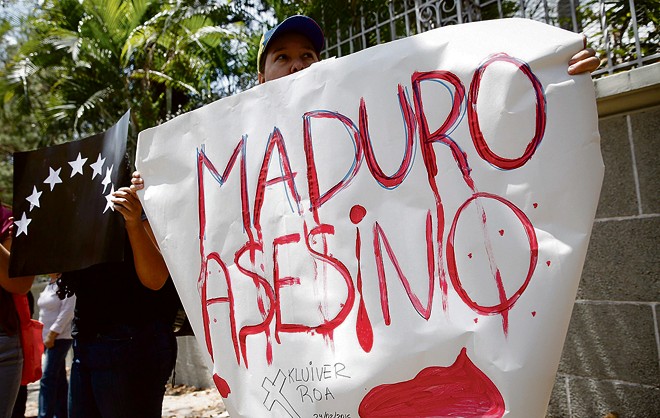 Jovem acusa Nicolás Maudro de assassino durante uma manisfestação em Caracas. | Carlos Garcia Rawlins/Reuters