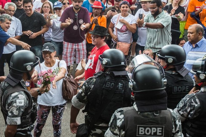 Servidora oferece flor para policial |