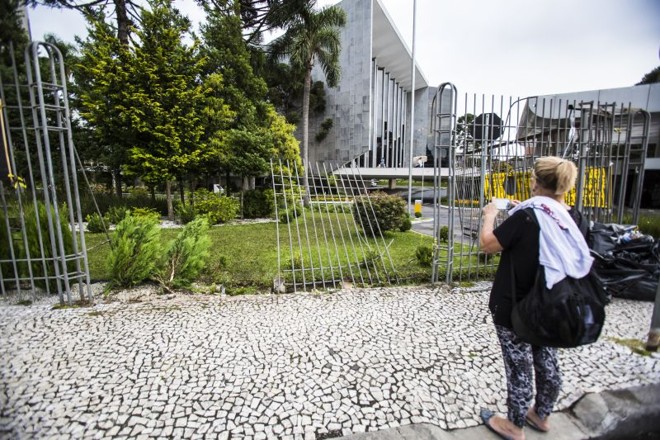 Mulher fotografa portão da Alep |