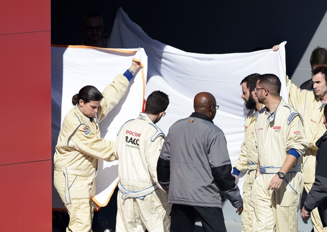 Os médicos protegem Fernando Alonso, deitado sobre a maca, em imagem que assustou a comunidade da Fórmula 1. | Stringer/ Reuters