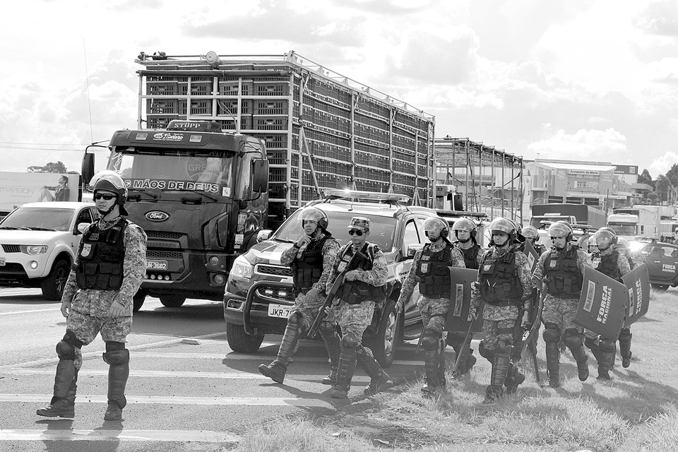 Agentes da Força Nacional tiveram de conter os manifestantes ontem, na BR-277, em Cascavel: fogo em pneus e carga na pista. | Luiz Carlos da Cruz/Gazeta do Povo