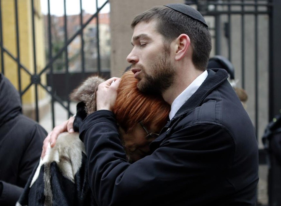 Rabino-chefe da Dinamarca conforta mulher no memorial a vítimas do ataque, em frente a uma sinagoga, em Copenhagen. | Leonhard Foeger/Reuters
