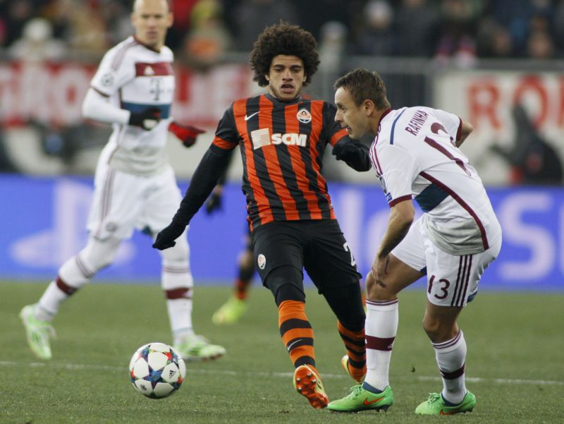 O brasileiro Rafinha, do Bayern de Munique, passa a bola antes da chegada de Taison, do Shakhtar, em empate sem gols na Ucrânia. | Valentyn Ogirenko/Reuters