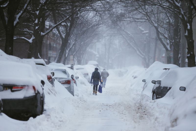 Pedestres caminham por rua coberta de neve em Cambridge, Massachusetts | Brian Snyder/Reuters