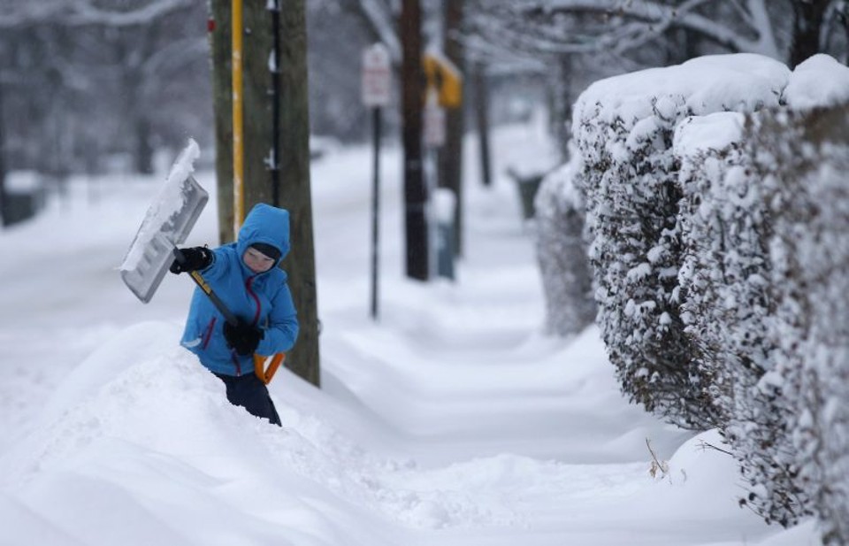 Garoto usa pá para retirar neve de rua de Nova York | Mike Segar/Reuters