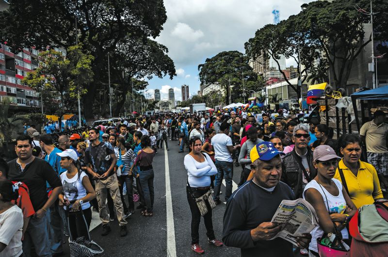 Em Caracas, tropas patrulham as filas de pessoas que querem comprar produtos básicos a preços subsidiados. Petróleo representa mais de 95% da renda | Meridith Kohut para The New York Times