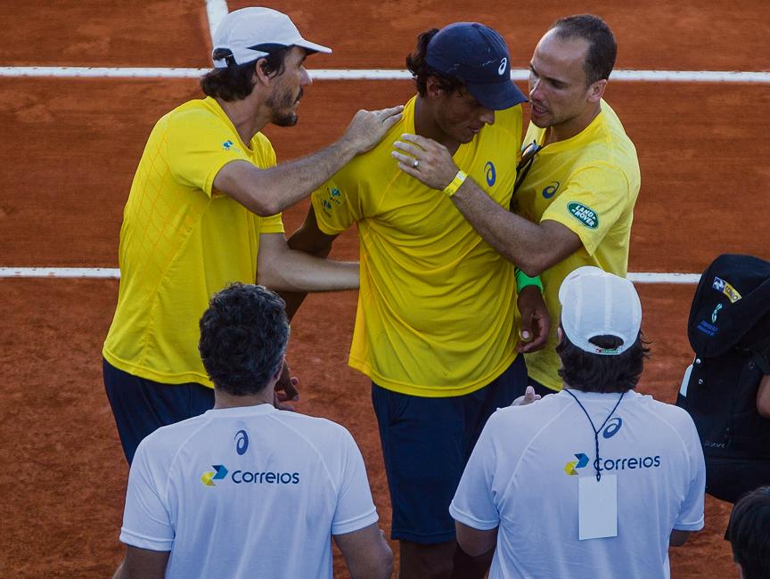 Equipe brasileira ampara João Souza, o Feijão, depois da derrota na partida mais longa da história da Copa Davis. | Ivan Fernandez/EFE