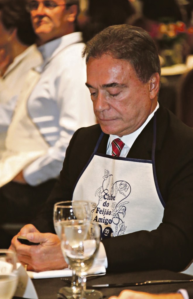 O senador Alvaro Dias confere mensagem no celular durante o jantar do Clube de Feijão Amigo, no Hotel Bourbon. Momentos antes, havia sido divulgada a lista dos políticos que serão investigados por envolvimento com a Operação Lava Jato. | Naideron Jr.