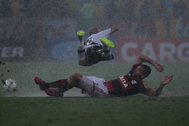Com o gramado encharcado, nem o sempre vigoroso Guiñazú escapou de levar um carrinho. | Gilvan Souza/ Fla Imagem