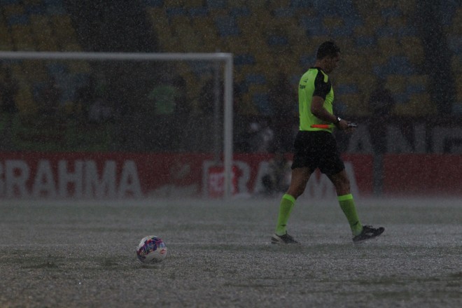 Com a bola parada, o bandeirinha se desloca para esperar o gramado ter condições de jogo novamente. | Gilvan Souza/ Fla Imagem