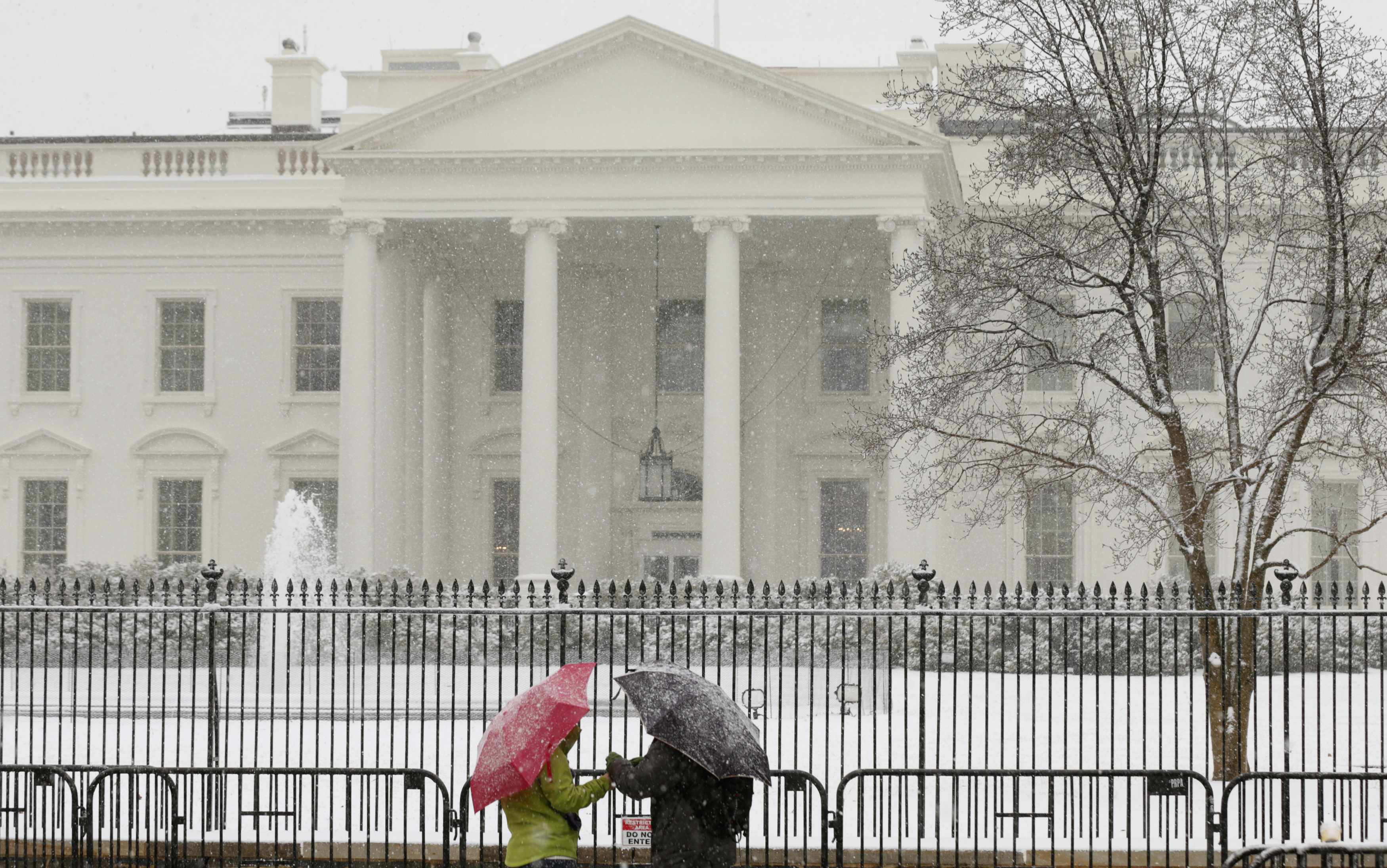 Casal tenta se proteger da neve em frente à Casa Branca | Kevin Lamarque/Reuters
