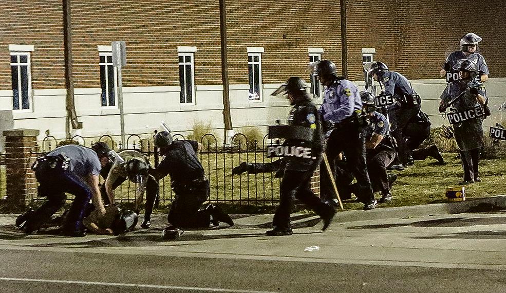 Policiais socorrem colega baleado durante protesto em Ferguson: agentes vêm sendo criticados por causa de violência contra negros. | Lawrence Bryant/Reuters