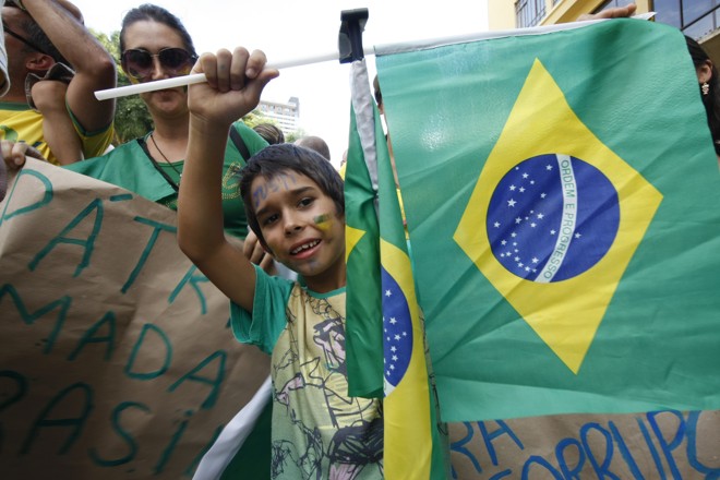 Garoto com bandeiras. | Aniele Nascimento/Gazeta do Povo