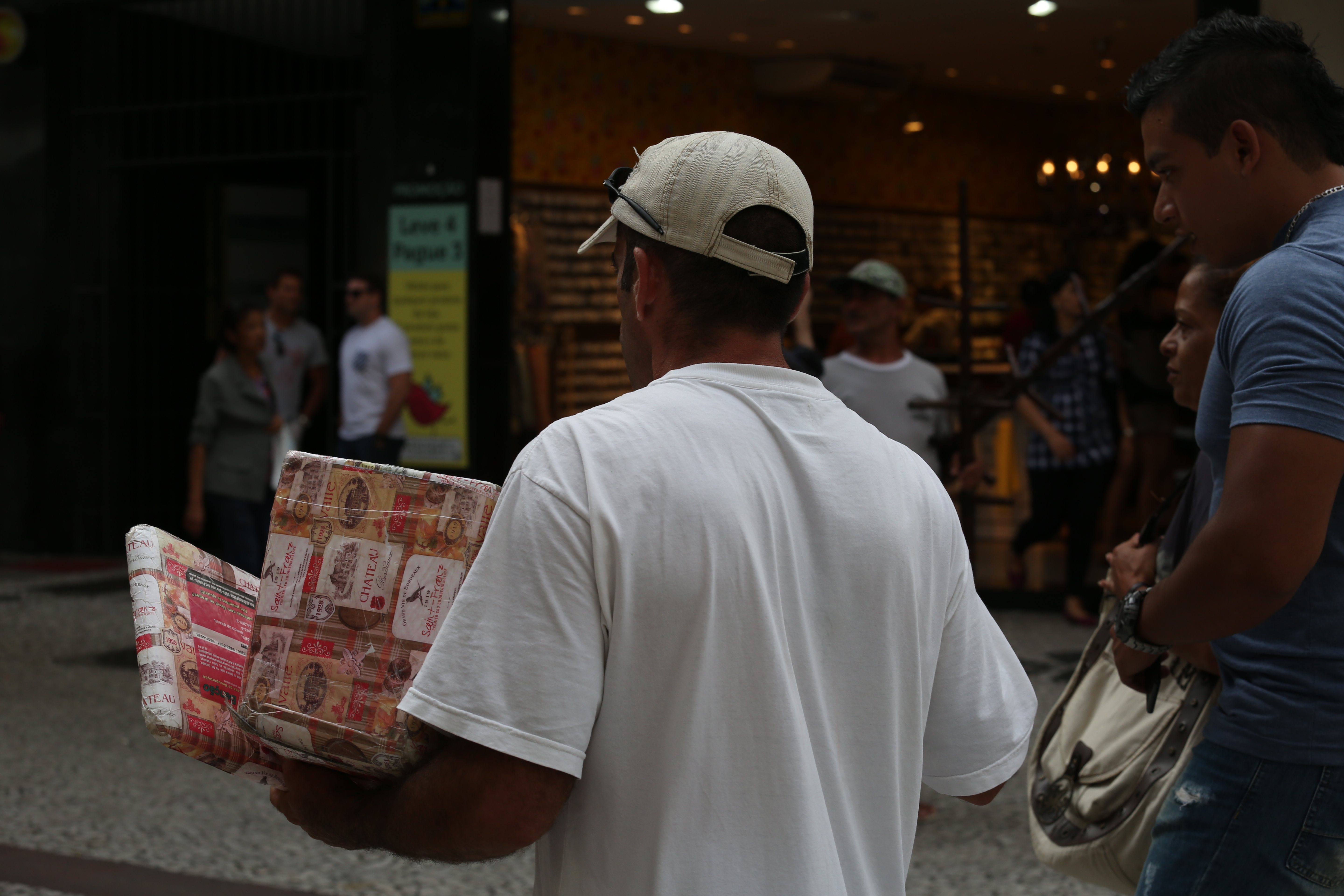 Integrante do projeto aborda transeuntes para vender alfajores | Ivonaldo Alexandre/Gazeta do Povo
