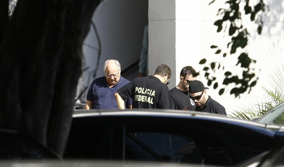 Duque (de camisa azul-marinho), ao ser preso, no Rio.  Ele seria transferido para Curitiba. | Alexandre Vieira/ Reuters