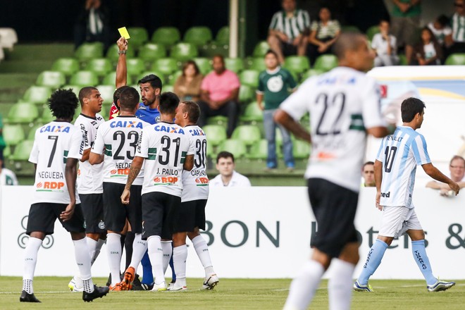 Cercado pelo time alviverde, Edvaldo Elias da Silva exibe o cartão amarelo. | Brunno Covello/Gazeta do Povo