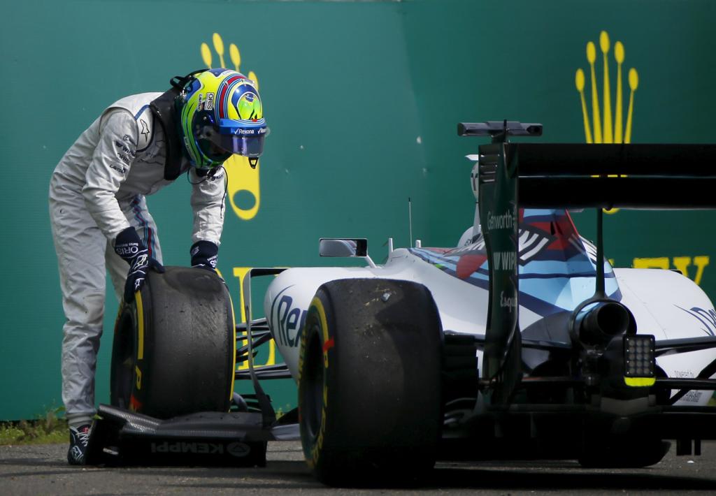 Felipe Massa mexe no pneu do carro após rodar e bater no treino livre em Xangai: 17ª colocação. | Carlos Barria/Reuters