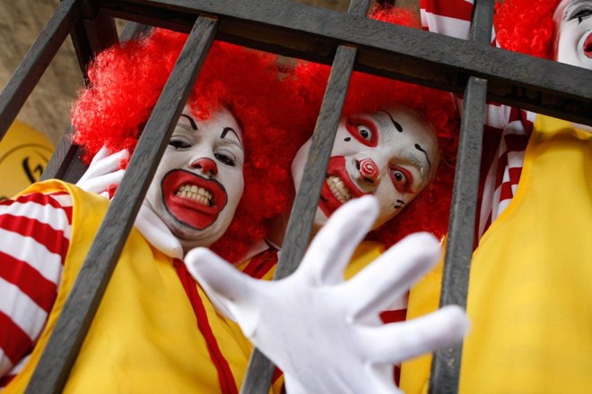 No saguão do Museu de Arte de São Paulo (MASP), cerca de 700 pessoas se reuniram com cartazes, muitas fantasiadas como o palhaço “Ronald McDonald”, e no final incendiaram um caixão simbolizando o enterro do personagem. | Carlos Villalba R./EFE