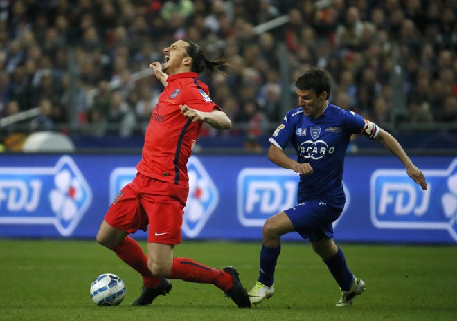 OUCH!: Zlatan Ibrahimovic (à esq.), do PSG, cai após ser atingido por Yannick Cahuzac, do Bastia, pelo campeonato francês. | GONZALO FUENTES/REUTERS