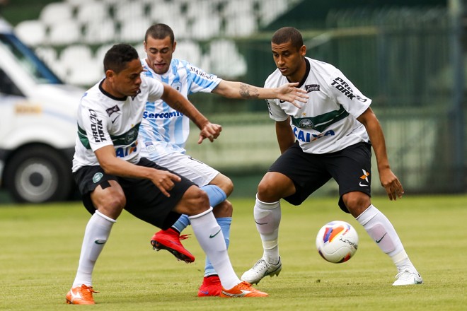 O perigoso Paulinho recebeu marcação forte e incansável, como neste lance com Hélder e Wellinton. | Brunno Covello/Gazeta do Povo